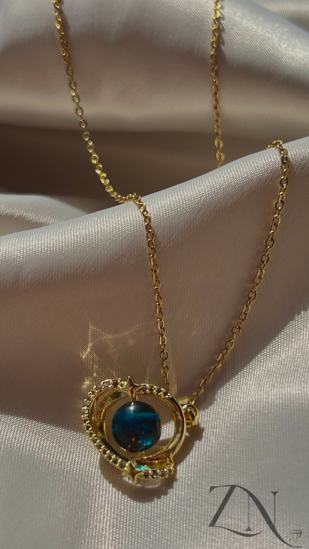 Celestial-inspired gold necklace featuring orbit and planet-like charm design.