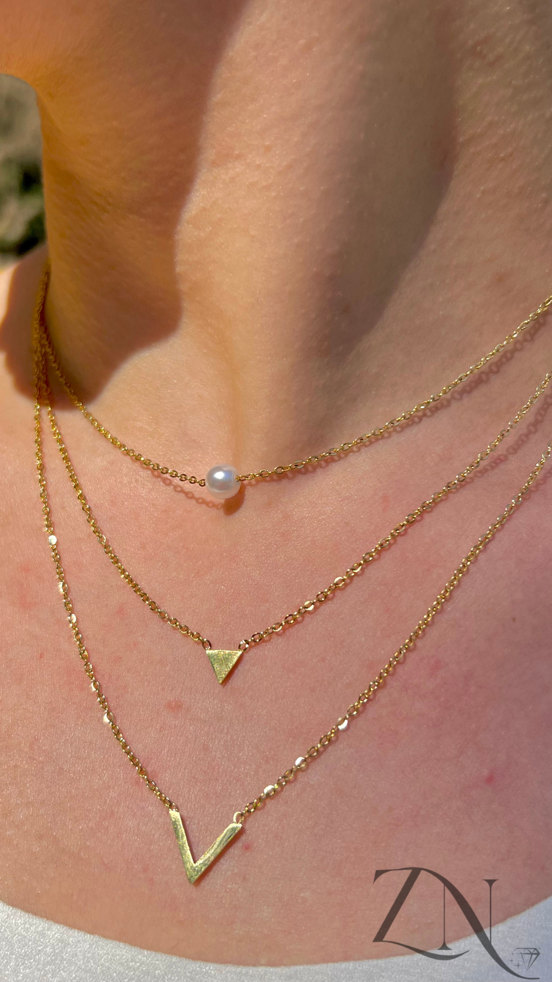 Triple-layer gold minimalist necklace with fine chains of varying lengths displayed flat.