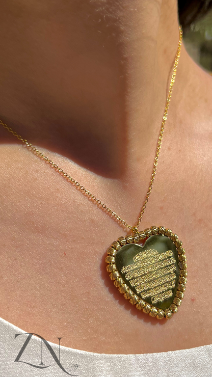 Gold heart-shaped pendant necklace engraved with Ayat Al-Kursi verse in Arabic calligraphy.