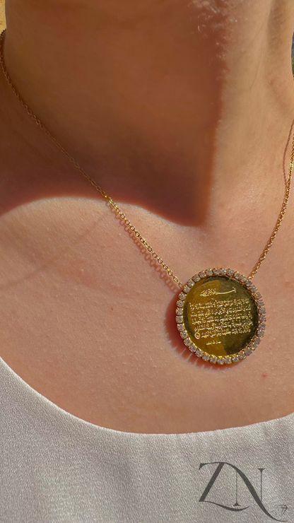 Gold round pendant necklace engraved with Ayat Al-Kursi verse in Arabic calligraphy.