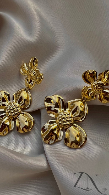 Gold-tone floral statement earrings with layered petal design and bold silhouette.