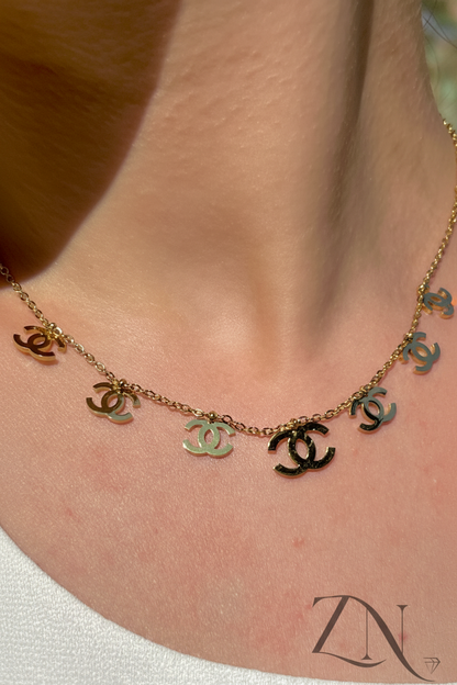 Gold-plated chain necklace with assorted luxury-inspired charms, styled in the spirit of Gucci design.