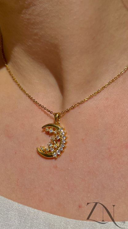 Delicate gold crescent moon necklace adorned with sparkling zirconia stones.
