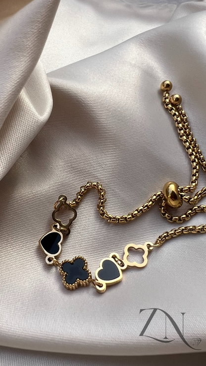 Gold-plated bracelet with alternating clover and heart charms in a delicate linked design.