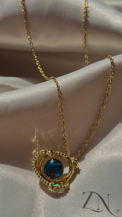 Celestial-inspired gold necklace featuring orbit and planet-like charm design.