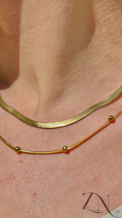 Gold serpentine chain with delicate beaded necklace duo on neck