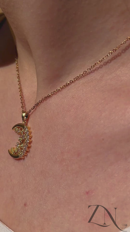 Crescent moon pendant necklace with zirconia accents shown worn, reflecting soft light and celestial charm.