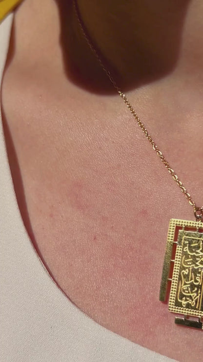 Elegant gold necklace featuring Arabic calligraphy pendant honoring mothers, shown styled on neckline.