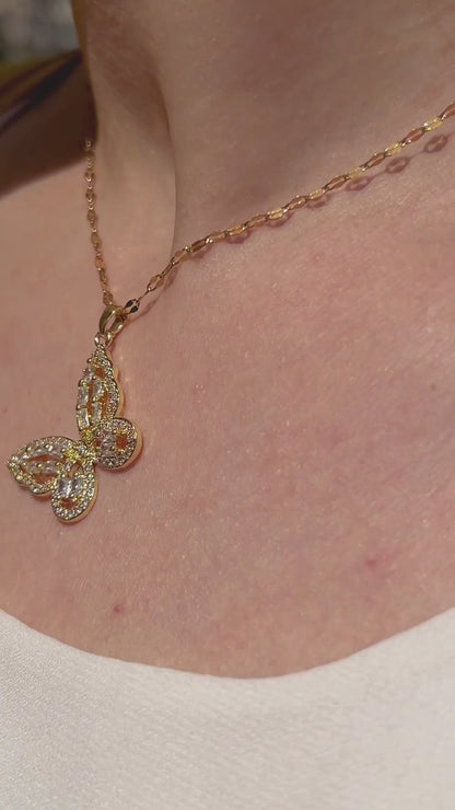 Radiant gold butterfly pendant necklace shown worn, capturing soft shimmer and graceful movement