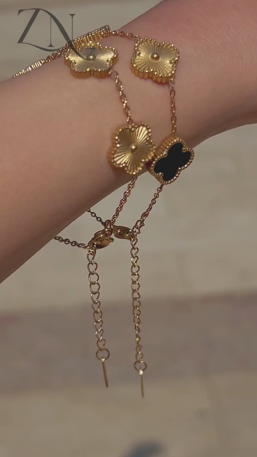 Clover-inspired gold bracelet with multi-colored charms, styled in the spirit of Van Cleef design.