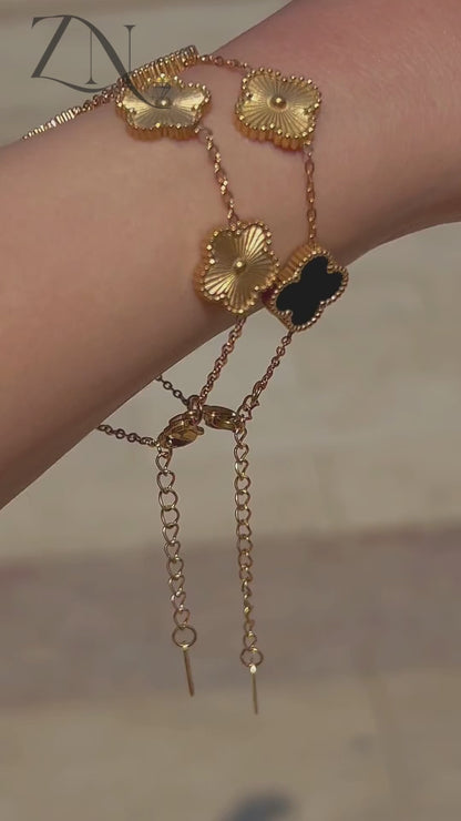 Clover-inspired gold bracelet with multi-colored charms, styled in the spirit of Van Cleef design.