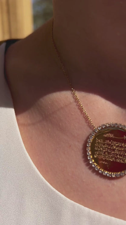 Close-up of round gold pendant featuring Ayat Al-Kursi engraving, shown worn with elegant shine