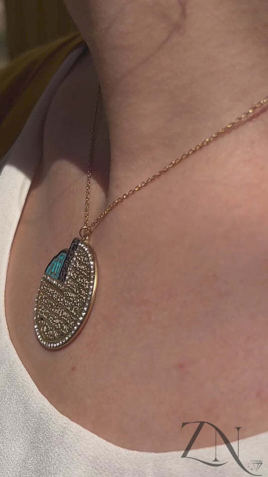Elegant blue and gold Ayat Al-Kursi pendant necklace shown worn, featuring Arabic calligraphy and radiant enamel finish.